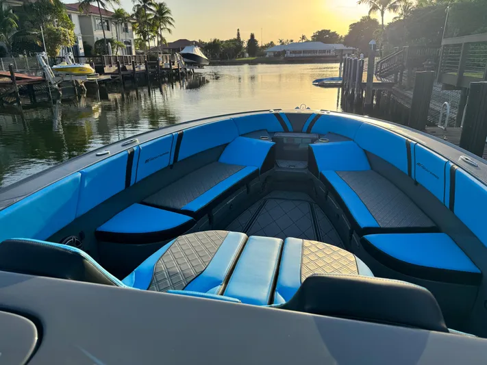 Do Better Yacht Photos Pics 2021 Midnight Express 37 Open boat with blue seating, docked at sunset.