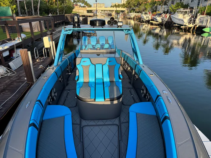 Do Better Yacht Photos Pics 2021 Midnight Express 37 Open boat with blue and gray seating, docked in a serene marina.