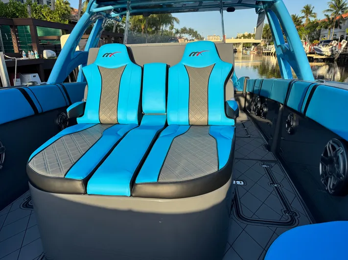 Do Better Yacht Photos Pics 2021 Midnight Express 37 Open boat with blue and gray seating, docked by a canal.