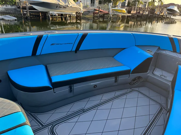 Do Better Yacht Photos Pics 2021 Midnight Express 37 Open boat interior with blue seating by the water.