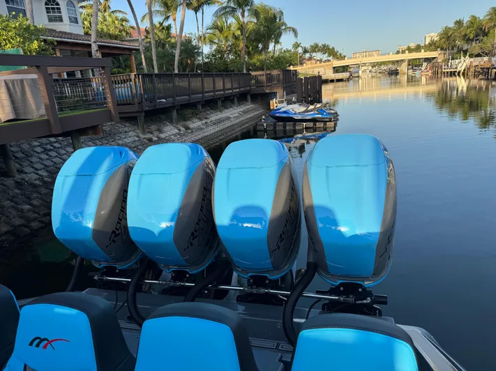 Do Better Yacht Photos Pics 2021 Midnight Express 37 Open boat with four blue outboard engines docked by a canal.
