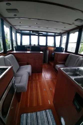 Moondance Yacht Photos Pics Interior of 2007 Custom Rockport Steel Trawler MY with wooden flooring and seating area.