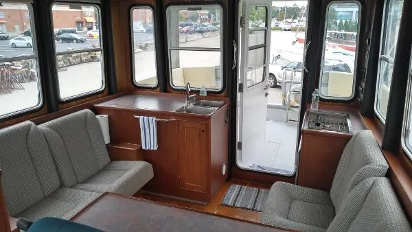 Moondance Yacht Photos Pics 2007 Custom Rockport Steel Trawler MY interior with seating, kitchenette, and large windows.