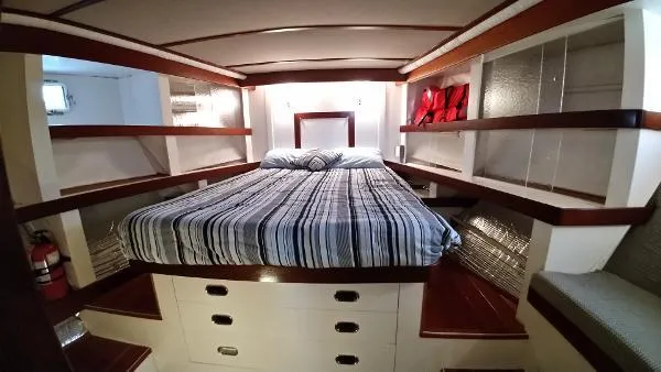 Moondance Yacht Photos Pics Luxurious bedroom in 2007 Custom Rockport Steel Trawler MY with striped bedding and ample storage.