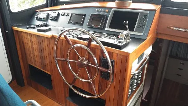 Moondance Yacht Photos Pics 2007 Custom Rockport Steel Trawler MY helm station with wooden wheel and modern navigation equipment.