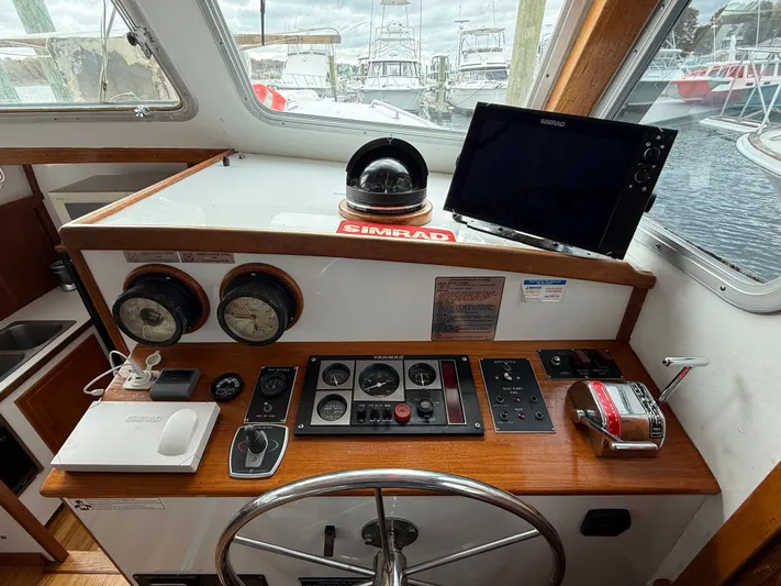 Screamer Yacht Photos Pics Helm of 1998 Wilbur 38 Downeast boat with navigation instruments and steering wheel.