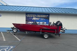 2021 Lund 1650 Angler SS boat on trailer, parked outside a fishing store.