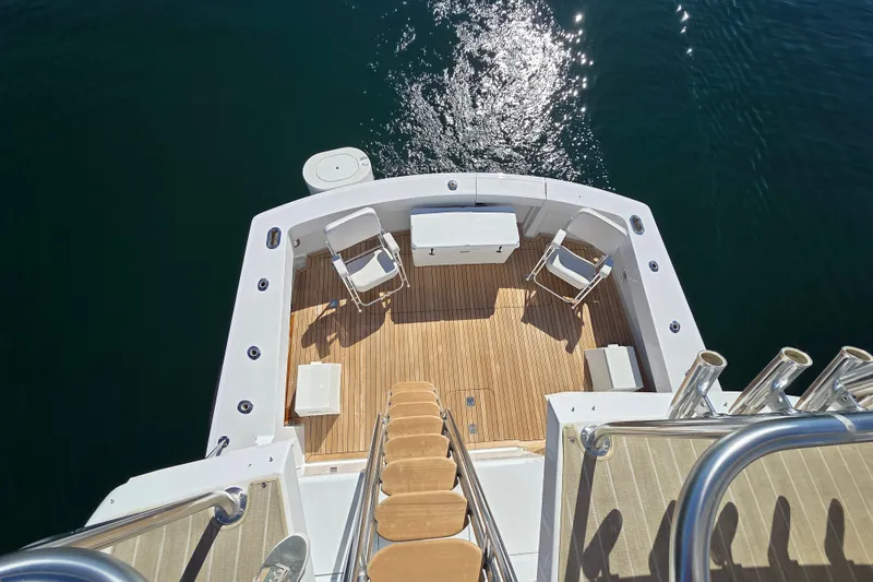  Yacht Photos Pics 2006 Hatteras 50 Convertible yacht deck with chairs and wooden flooring.