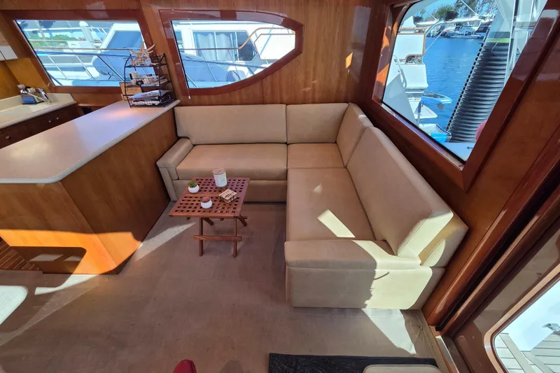  Yacht Photos Pics Luxurious interior of 2006 Hatteras 50 Convertible yacht with beige sofa and wooden accents.