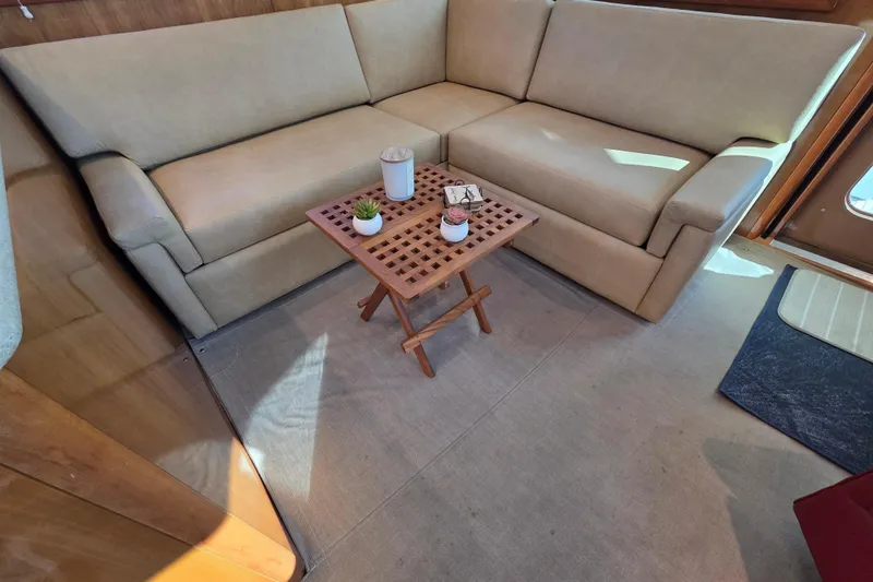  Yacht Photos Pics Luxurious interior of 2006 Hatteras 50 Convertible yacht with beige sofa and wooden table.