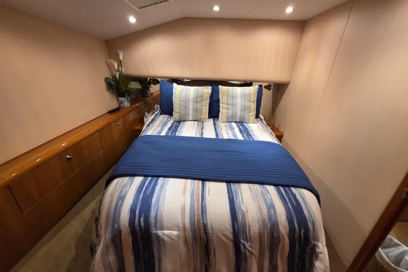  Yacht Photos Pics Luxurious bedroom interior of 2006 Hatteras 50 Convertible yacht with striped bedding.