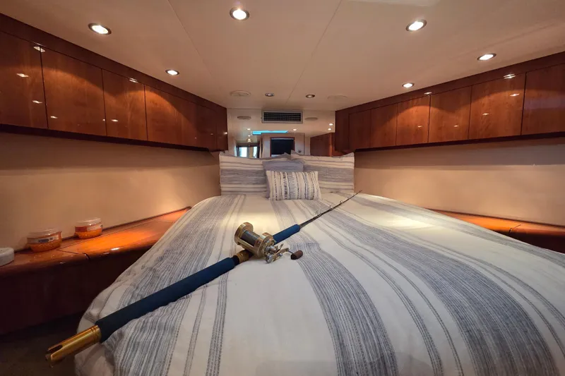  Yacht Photos Pics Luxurious cabin interior of 2006 Hatteras 50 Convertible yacht with fishing rod on bed.