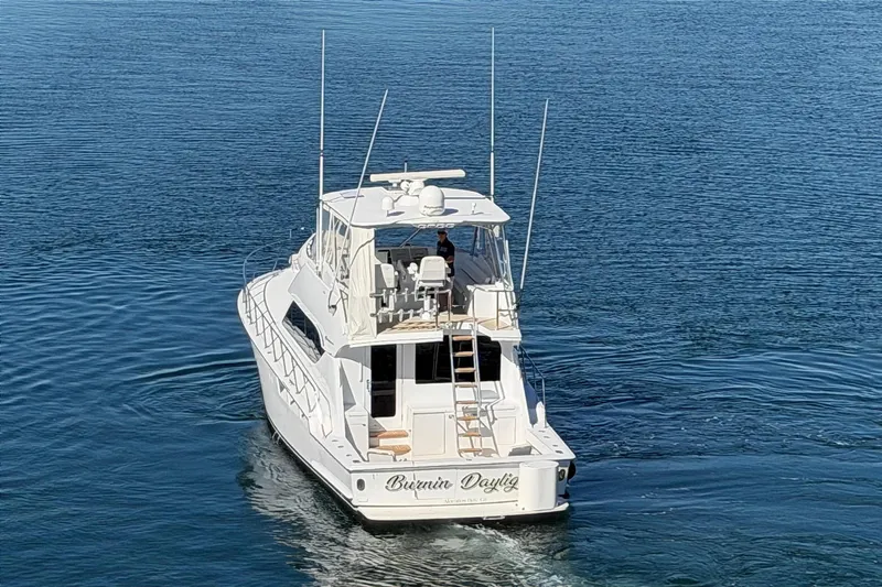  Yacht Photos Pics 2005 Hatteras 50 Convertible yacht cruising on calm blue waters.