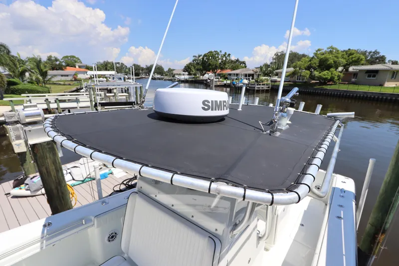  Yacht Photos Pics 2013 Yellowfin 32 Offshore boat with Simrad radar, docked in a scenic canal setting.