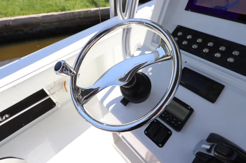  Yacht Photos Pics Steering wheel of a 2013 Yellowfin 32 Offshore boat, featuring control panel and instruments.
