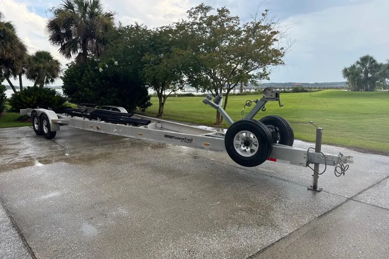  Yacht Photos Pics Trailer for 2013 Yellowfin 32 Offshore boat on wet driveway, surrounded by trees.
