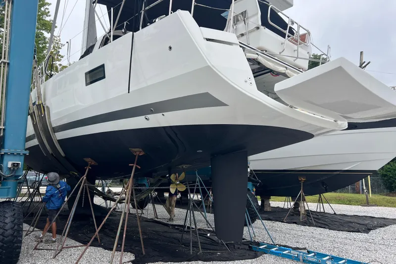  Yacht Photos Pics 2023 Jeanneau 65 yacht on stands, undergoing maintenance in a boatyard.