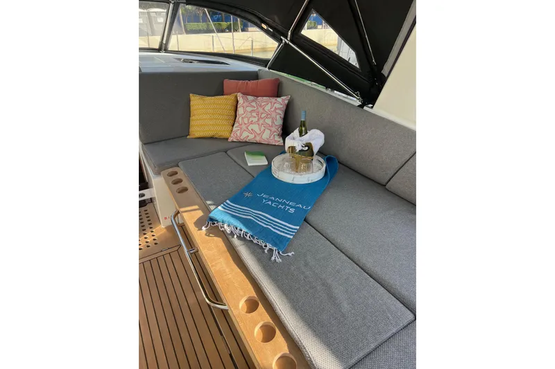  Yacht Photos Pics Luxurious seating area on 2023 Jeanneau 65 yacht with cushions and wine setup.