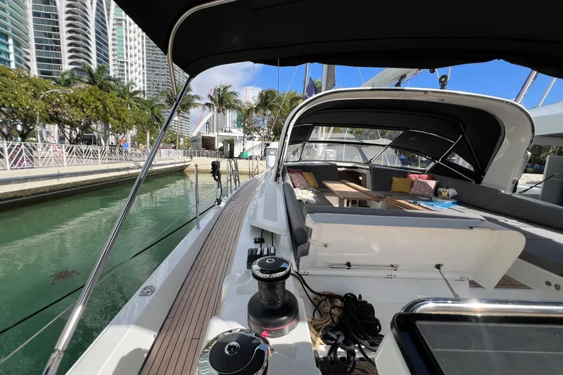  Yacht Photos Pics 2023 Jeanneau 65 yacht docked, featuring spacious deck and modern seating area.