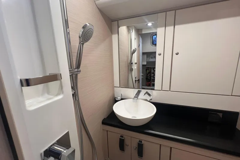  Yacht Photos Pics Modern bathroom interior of 2023 Jeanneau 65 yacht with sleek fixtures and mirror.