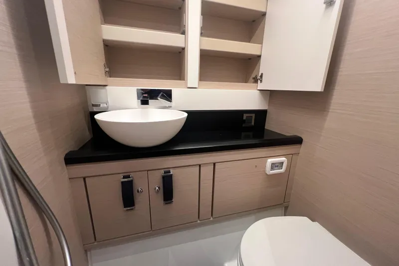  Yacht Photos Pics Modern bathroom in 2023 Jeanneau 65 yacht with sleek sink and cabinetry.