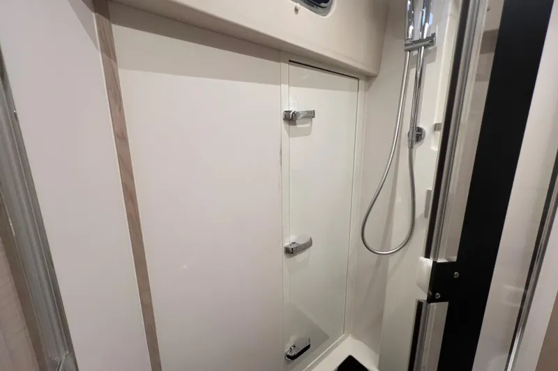  Yacht Photos Pics Modern shower area in 2023 Jeanneau 65 yacht, featuring sleek design and chrome fixtures.
