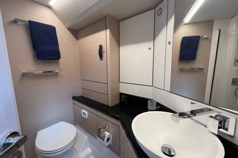  Yacht Photos Pics Modern bathroom in 2023 Jeanneau 65 yacht with sleek fixtures and elegant design.