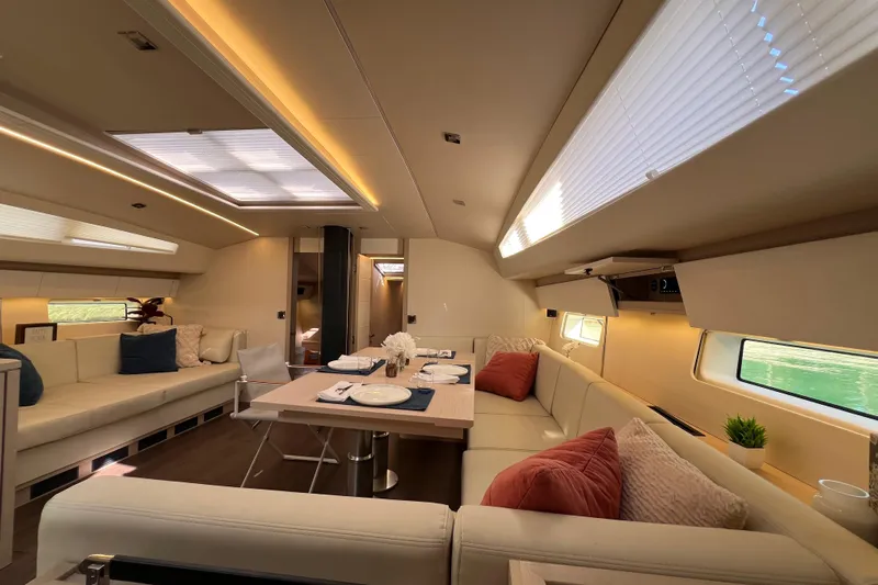  Yacht Photos Pics Luxurious interior of 2023 Jeanneau 65 yacht with elegant dining area and plush seating.