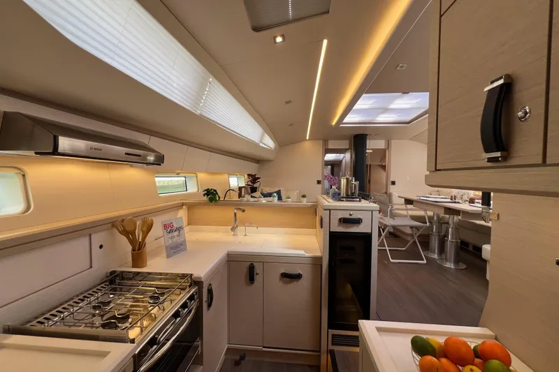  Yacht Photos Pics Luxurious interior of 2023 Jeanneau 65 yacht featuring modern kitchen and dining area.