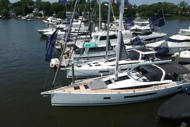  Yacht Photos Pics 2023 Jeanneau 65 yacht docked among other boats in a marina setting.