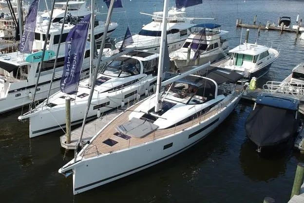  Yacht Photos Pics 2023 Jeanneau 65 yacht docked at marina, surrounded by other boats.
