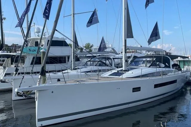  Yacht Photos Pics 2023 Jeanneau 65 yacht docked at marina, showcasing sleek design and modern features.