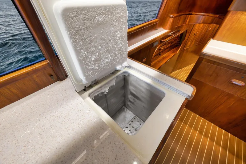  Yacht Photos Pics 1997 Garlington 61 yacht interior with open freezer, showcasing wooden cabinetry and ocean view.