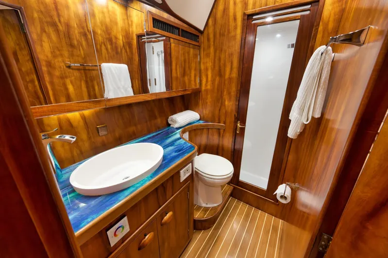  Yacht Photos Pics Luxurious wooden bathroom interior in 1997 Garlington 61 yacht, featuring modern sink and shower.