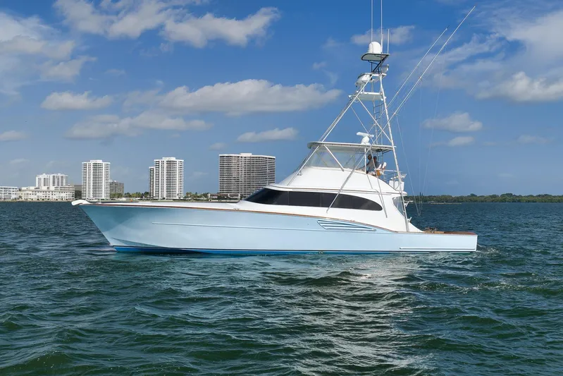  Yacht Photos Pics A 1997 Garlington 61 yacht cruising on a sunny day with city skyline backdrop.