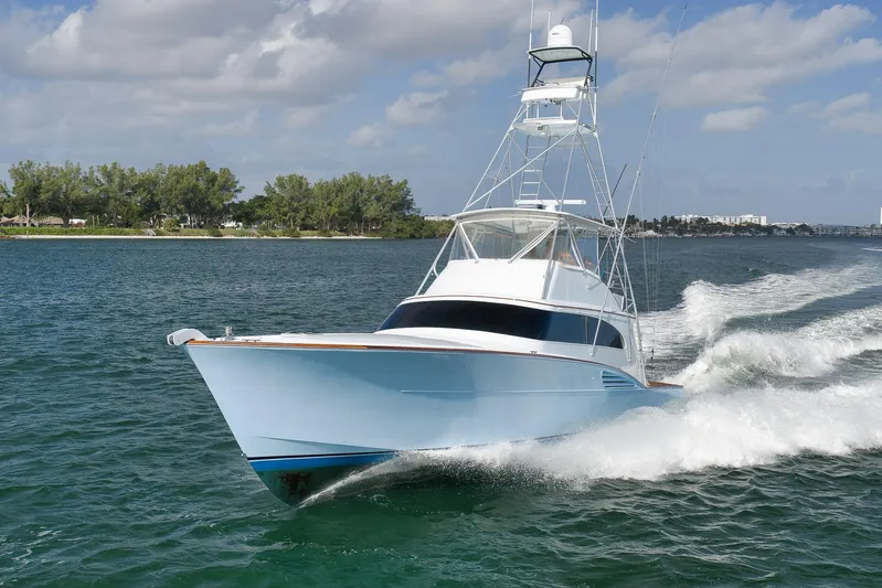  Yacht Photos Pics 1997 Garlington 61 yacht cruising on a sunny day, creating waves in the water.