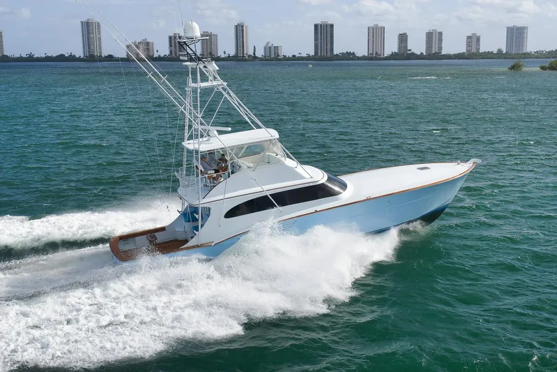  Yacht Photos Pics 1997 Garlington 61 yacht cruising on open water with city skyline in background.