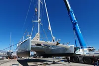 Catamaran NIMBLE 50 (2001) being lifted by crane at a shipyard.