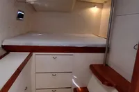 Cabin interior of 2001 Catamaran NIMBLE 50 with bed, drawers, and wooden accents.
