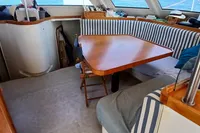 Interior of 2001 Catamaran NIMBLE 50 with striped seating and wooden table.