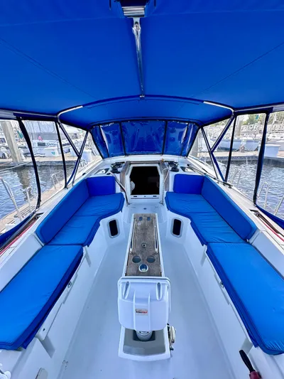 Volare Yacht Photos Pics 2014 Jeanneau Sun Odyssey 44 DS cockpit with blue seating and canopy, docked at marina.