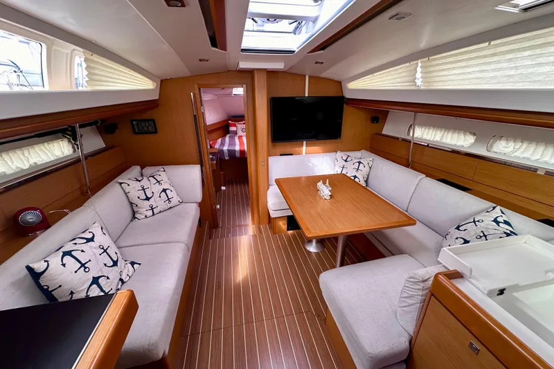 Volare Yacht Photos Pics Luxurious interior of 2014 Jeanneau Sun Odyssey 44 DS yacht with cozy seating and elegant decor.
