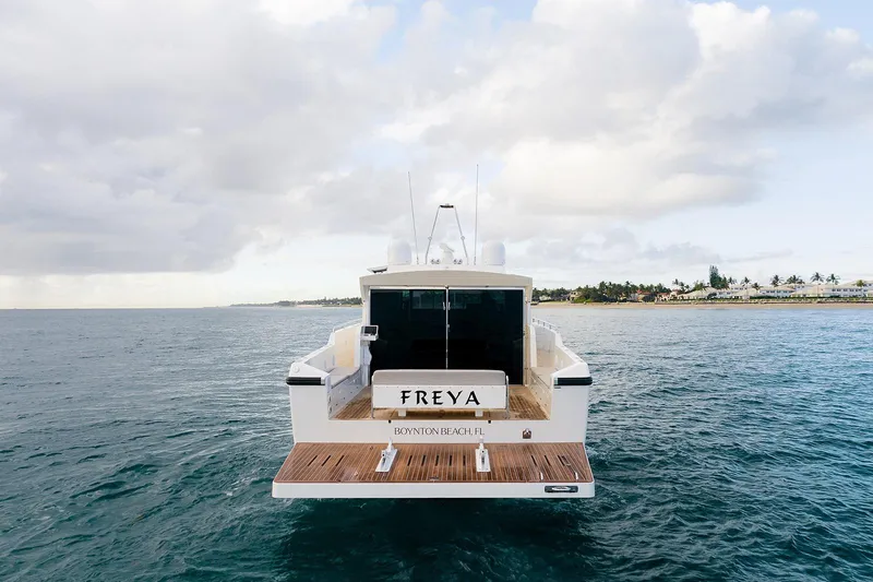 Freya Yacht Photos Pics Delta Powerboats 54 IPS 2023 yacht on ocean, rear view with "FREYA" name.