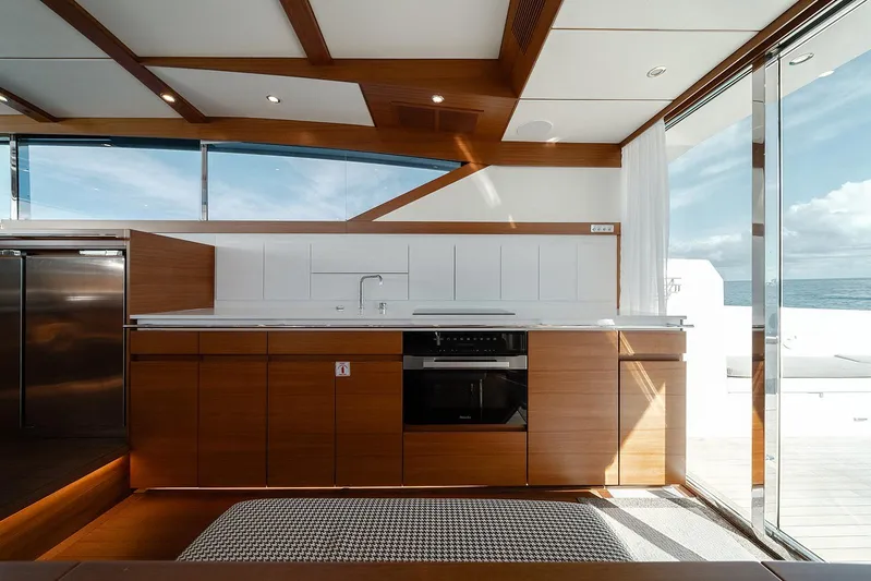 Freya Yacht Photos Pics Modern kitchen interior on 2023 Delta Powerboats 54 IPS yacht, featuring sleek wood cabinetry and ocean view.