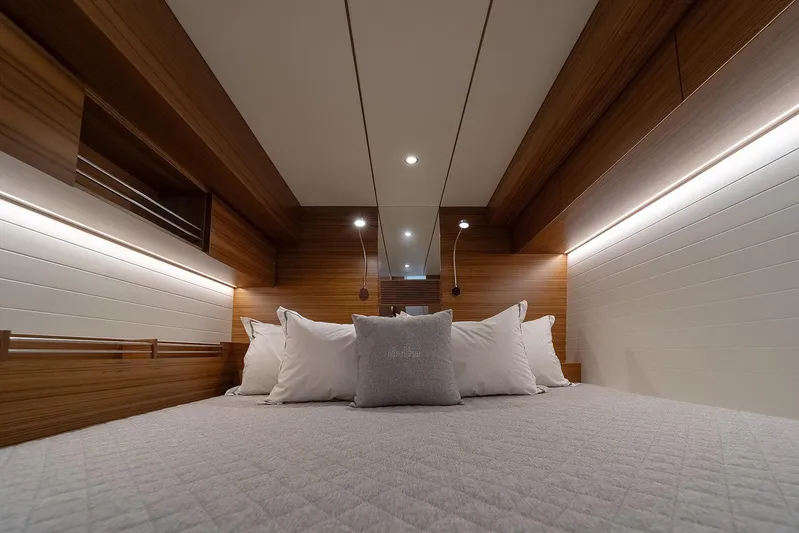 Freya Yacht Photos Pics Luxurious cabin interior of 2023 Delta Powerboats 54 IPS, featuring elegant wood paneling and cozy bedding.
