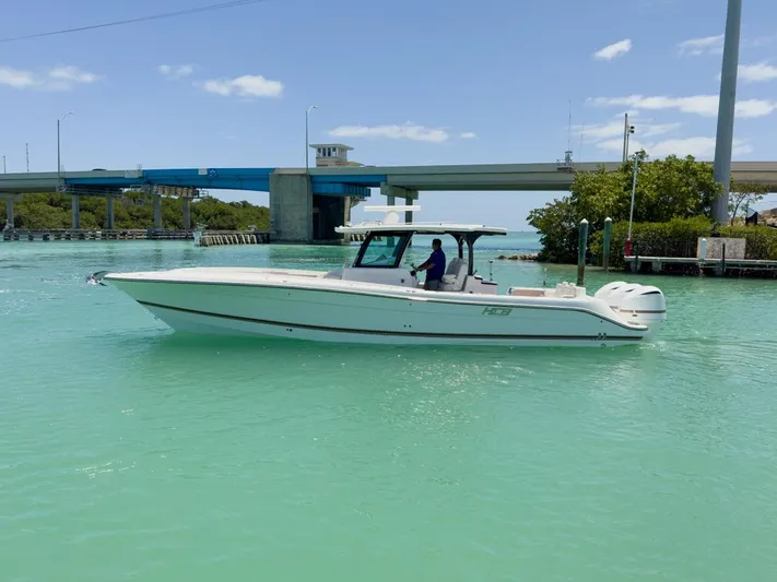 Aquamarine Yacht Photos Pics 2019 HCB 39 Speciale boat cruising on turquoise water near a bridge.
