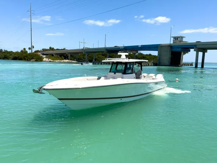 Aquamarine Yacht Photos Pics 2019 HCB 39 Speciale boat cruising in turquoise waters near a bridge.