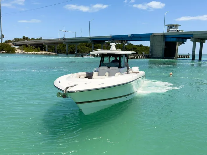 Aquamarine Yacht Photos Pics 2019 HCB 39 Speciale boat cruising in turquoise waters near a bridge.