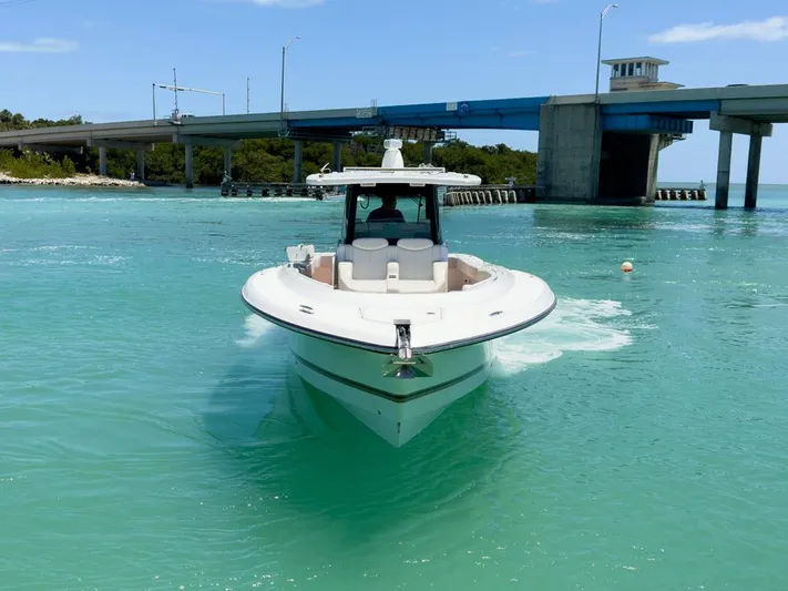 Aquamarine Yacht Photos Pics 2019 HCB 39 Speciale boat cruising in turquoise waters near a bridge.