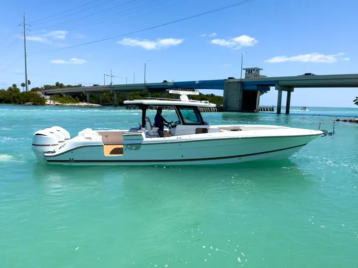 Aquamarine Yacht Photos Pics 2019 HCB 39 Speciale boat cruising on turquoise water near a bridge.